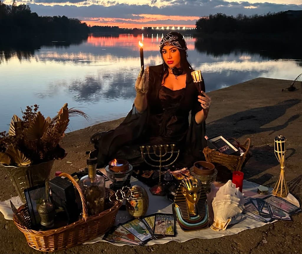 Cassiana la ritual pe malul apei, la apus, cu tarot și lumânări